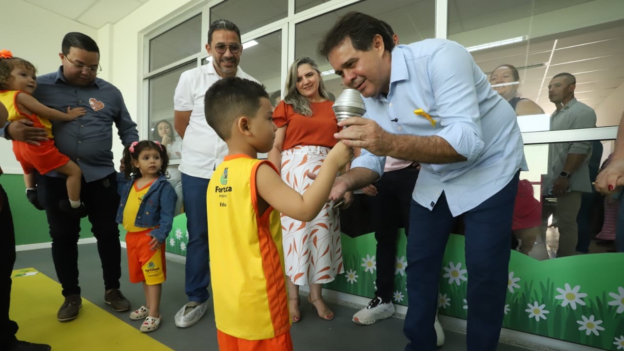 prefeito conversa com um aluno numa escola